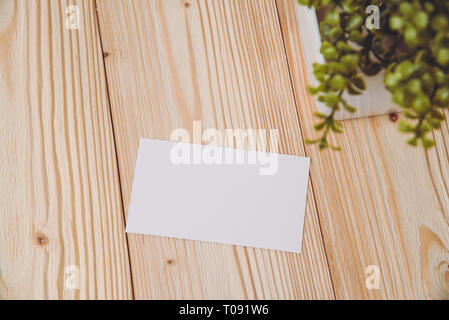 Blank business cards and little decorative tree in white vase on wooden working table with copy space for add text ID. and logo, business company conc Stock Photo