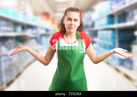 Female hypermarket or supermarket employee making confused gesture with palms up and expression as innocent concept Stock Photo
