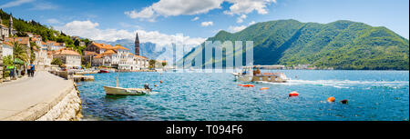 Classic panorama view of the historic town of Perast located at world-famous Bay of Kotor on a beautiful sunny day with blue sky and clouds in summer, Stock Photo