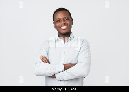 Laughing handsome young african man in shirt smiling confident Stock Photo