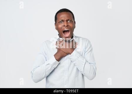 Young african man having asthma attack or choking can not breath suffering from respiration problems Stock Photo