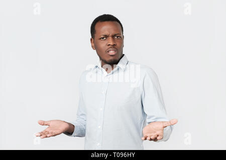doubtful african man shrugs shoulders with confusion Stock Photo