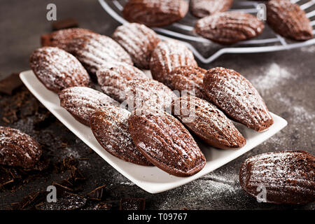 Chocolate cookies. Homemade Chocolate Madeleines on dark table. French cuisine. Stock Photo