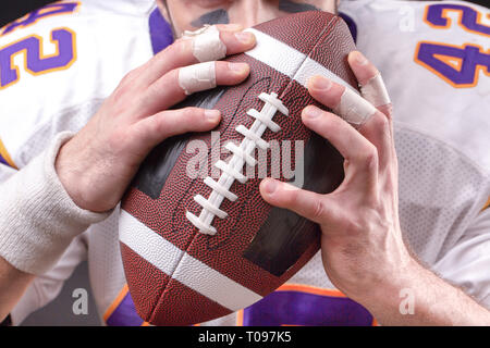 Cropped Image Of Sportsman Holding American Football Ball Stock Photo