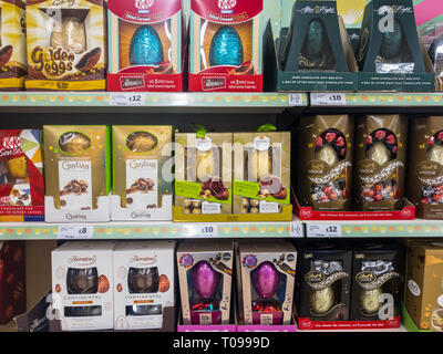 Exeter, Devon , England, March, 14, 2019: A UK supermarket filled shelves selling large and expensive chocolate Easter Eggs. Lots of purple and red in Stock Photo