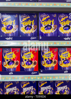 Exeter, Devon , England, March, 14, 2019: A UK supermarket filled shelves selling chocolate Easter Eggs. Lots of purple and red in the image, vertical Stock Photo