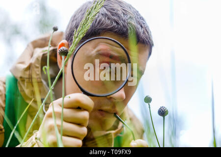 Photo of brunet biologist with magnifying glass Stock Photo