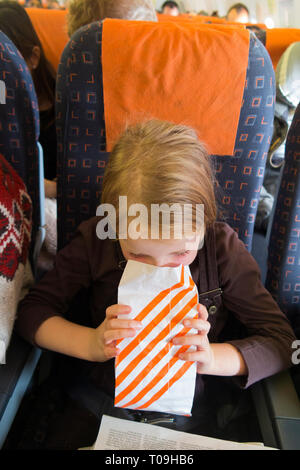 Kid / child / girl / person / people / children with airsickness vomiting during a flight / being sick on a plane / airplane. (104) Stock Photo