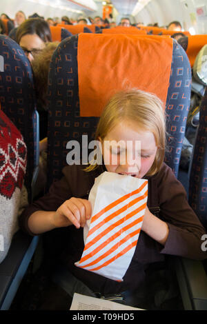 Kid / child / girl / person / people / children with airsickness vomiting during a flight / being sick on a plane / airplane. (104) Stock Photo