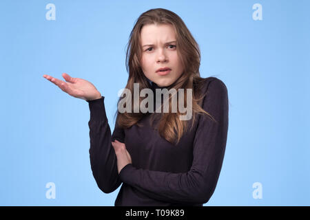 Displeased young woman frowning and staring at camera with judgemental look Stock Photo