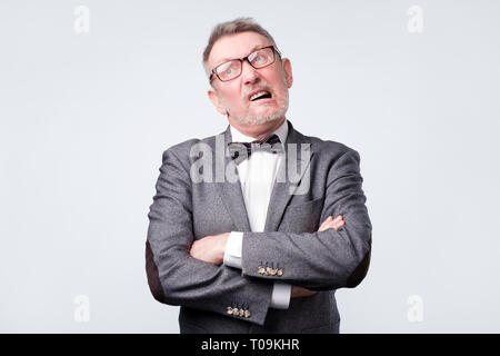Mature man in suit and glasses with skeptic look, has some doubts Stock Photo