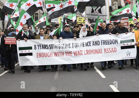 London, Greater London, UK. 16th Mar, 2019. Protesters are seen holding a banner and flags during the 8th Anniversary of the Syrian Revolution protest.Syrians marched from Paddington Green to Whitehall to demand for a peaceful solution of the war in Syria and restore democracy, they also call for an end of forced displacement, war crimes and foreign occupation in the country. Credit: Andres Pantoja/SOPA Images/ZUMA Wire/Alamy Live News Stock Photo