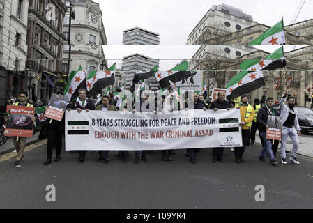 London, Greater London, UK. 16th Mar, 2019. Protesters are seen holding a banner and flags during the 8th Anniversary of the Syrian Revolution protest.Syrians marched from Paddington Green to Whitehall to demand for a peaceful solution of the war in Syria and restore democracy, they also call for an end of forced displacement, war crimes and foreign occupation in the country. Credit: Andres Pantoja/SOPA Images/ZUMA Wire/Alamy Live News Stock Photo