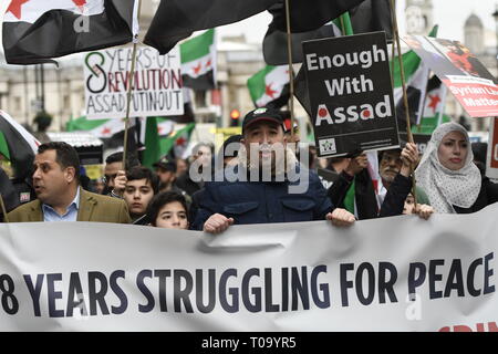 London, Greater London, UK. 16th Mar, 2019. Protesters are seen holding a banner and placard during the 8th Anniversary of the Syrian Revolution protest.Syrians marched from Paddington Green to Whitehall to demand for a peaceful solution of the war in Syria and restore democracy, they also call for an end of forced displacement, war crimes and foreign occupation in the country. Credit: Andres Pantoja/SOPA Images/ZUMA Wire/Alamy Live News Stock Photo
