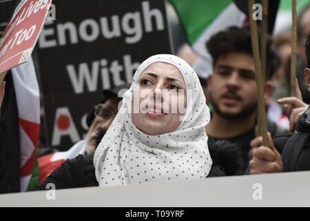 London, Greater London, UK. 16th Mar, 2019. A woman seen holding a placard during the 8th Anniversary of the Syrian Revolution protest.Syrians marched from Paddington Green to Whitehall to demand for a peaceful solution of the war in Syria and restore democracy, they also call for an end of forced displacement, war crimes and foreign occupation in the country. Credit: Andres Pantoja/SOPA Images/ZUMA Wire/Alamy Live News Stock Photo