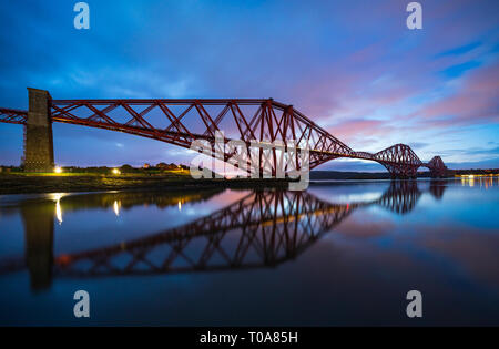 North Queensferry, Scotland, UK. 18th Mar, 2019. Soft pink light one hour before sunrise highlights the clouds above the Forth Bridge on a calm windless morning at North Queensferry in Fife, Scotland. Credit: Iain Masterton/Alamy Live News