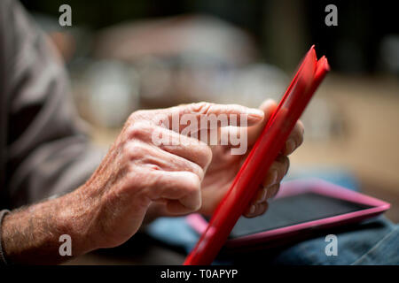 Hands of a senior man using a digital tablet. Stock Photo