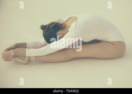 Training her flexibility. Ballet dancer doing stretching exercise. Ballerina in ballet class. Pretty woman in dance wear. Practicing classical ballet Stock Photo