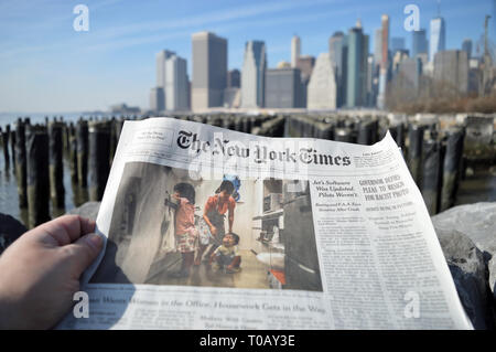 New York City, USA - February 3, 2019: The New York Times newspaper against a Lower Manhattan skyline. Stock Photo