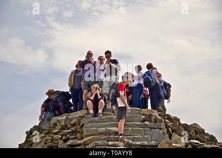 Hikers congregate at the summit of Mount Snowdon, Gwynedd, North Wales, UK Stock Photo