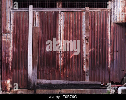 old detailed aged vintage rusty corrugated red brown textured zinc alloy metal sheet exterior fence used in construction industry as a house building  Stock Photo