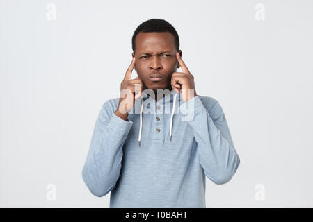 African american man keeps fingers on temples selects best suitable solution Stock Photo