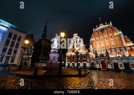 RIGA, LATVIA - MARCH 17, 2019: Professional long exposure shot at a rainy night facing House of Blackheads, statue of Roland and St. Peter's church Stock Photo