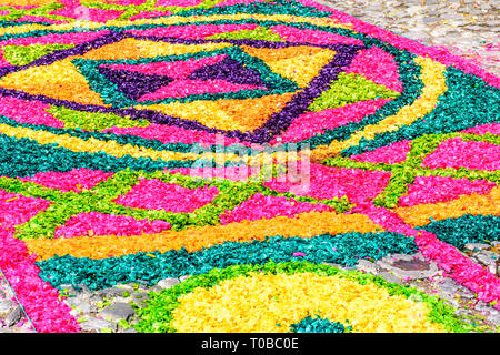 Antigua, Guatemala -  March 25, 2018: Dyed sawdust Palm Sunday procession carpet in town with famous Holy Week celebrations. Stock Photo