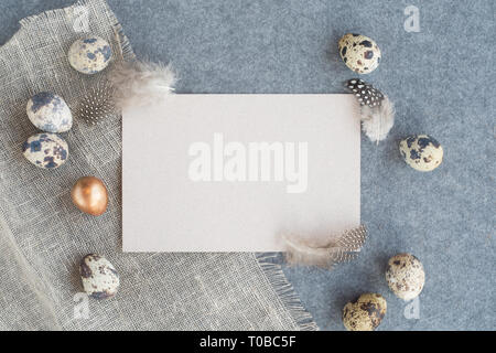 Easter greeting card with copy space for text and beautiful decor of eggs and feathers on fabric background pastel colored template for design Stock Photo