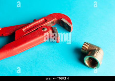 A monkey wrench on the blue background with some fitting connectors. for design and decoration. Stock Photo