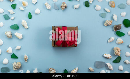 Banner Different sea shells on gray background packing with gift. Top view flat lay toned. Rad bow Stock Photo