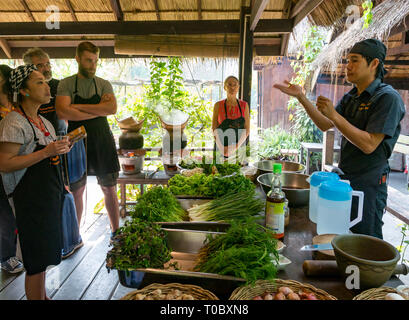Tourists in SE Asian Lao cooking lesson with instruction from Lao chef at Tamarind cookery school, Luang Prabang, Laos Stock Photo