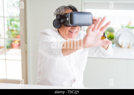 Man wearing virtual reality glasses smiling looking very happy and excited Stock Photo