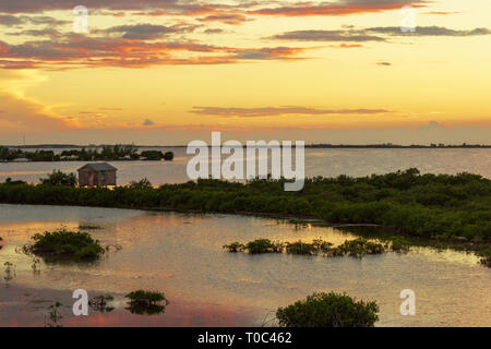 The sun sets over Chetumal Bay off Ambergris Caye, Belize casting brilliant hues across the sky and reflecting in the waters rippled by a warm breeze. Stock Photo