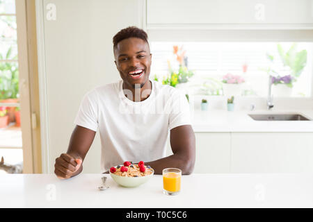 Handsome african american man eating heatlhy cereals and berries as breakfast Stock Photo