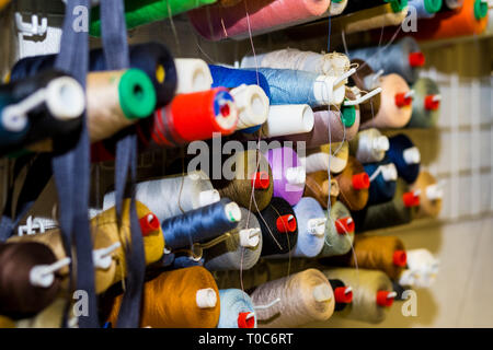 Colorful embroidery thread spool using in garment industry, row of multicolored yarn rolls, sewing material selling in the market.Set of threads on Stock Photo
