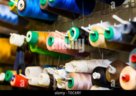 Colorful embroidery thread spool using in garment industry, row of multicolored yarn rolls, sewing material selling in the market.Set of threads on Stock Photo
