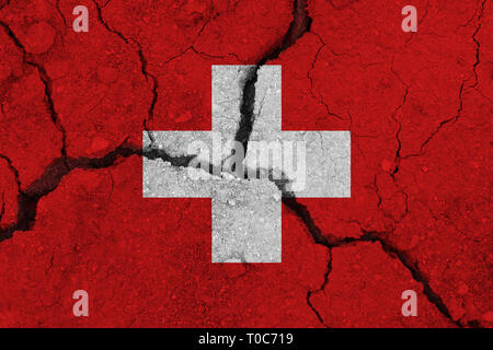 Switzerland flag on the cracked earth. National flag of Switzerland. Earthquake or drought concept Stock Photo