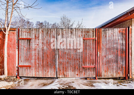 Wooden ancient gate by the house at spring time. Stock Photo