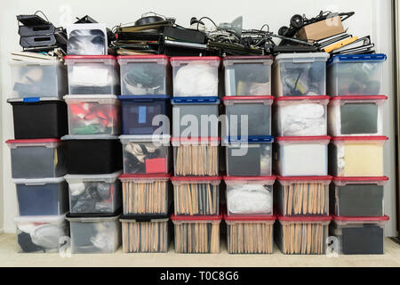 Tall wall of plastic file storage boxes with folders, binders and miscellaneous business office supplies. Stock Photo