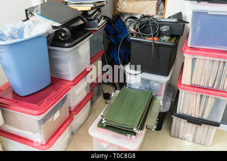 Messy office overflow storage area with boxes, binders, folders and miscellaneous supplies. Stock Photo