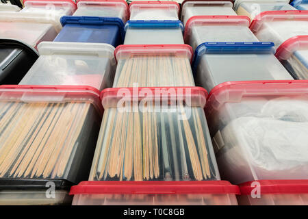 Tall wall of plastic file storage boxes with folders, binders and miscellaneous supplies. Stock Photo