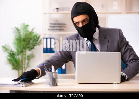 Male gangster stealing information from the office Stock Photo