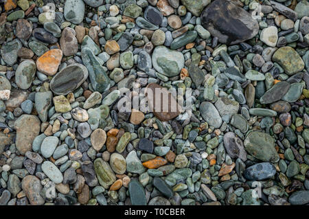 Multi-coloured pebbles rounded along the bank of a river stream in Kashmir Stock Photo