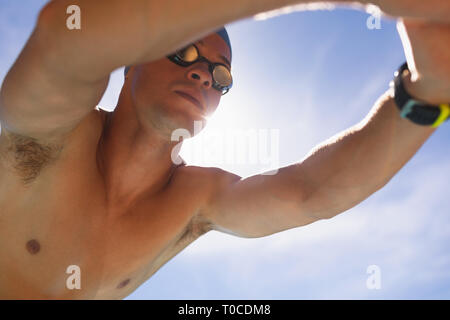 Male swimmer in starting position at swimming pool Stock Photo