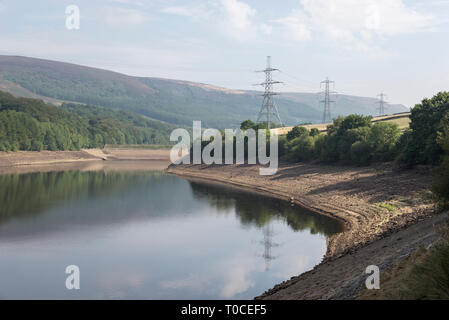 Sunny summer morning at Bottom's reservoir in the Longdendale valley, Derbyshire, England. Pylons reflected in the water. Stock Photo