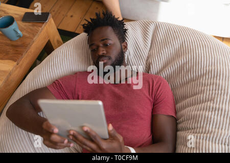 Man using digital tablet in living room at home