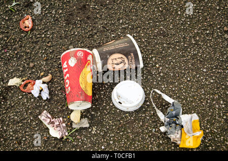 LONDON, UK - JANUARY 28, 2016:  Overhead view of discarded coffee cups a bag and some food left on a pavement. Includes cups from Costa and Patisserie Stock Photo
