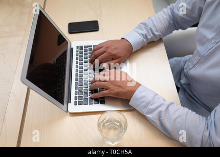 Businessman working on laptop at desk in office Stock Photo