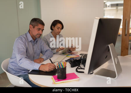 Graphic designers working at desk in office Stock Photo
